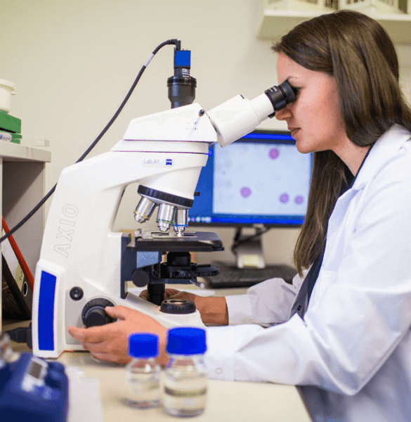 Wissenschaftlerin im Labor an einen Mikroskop